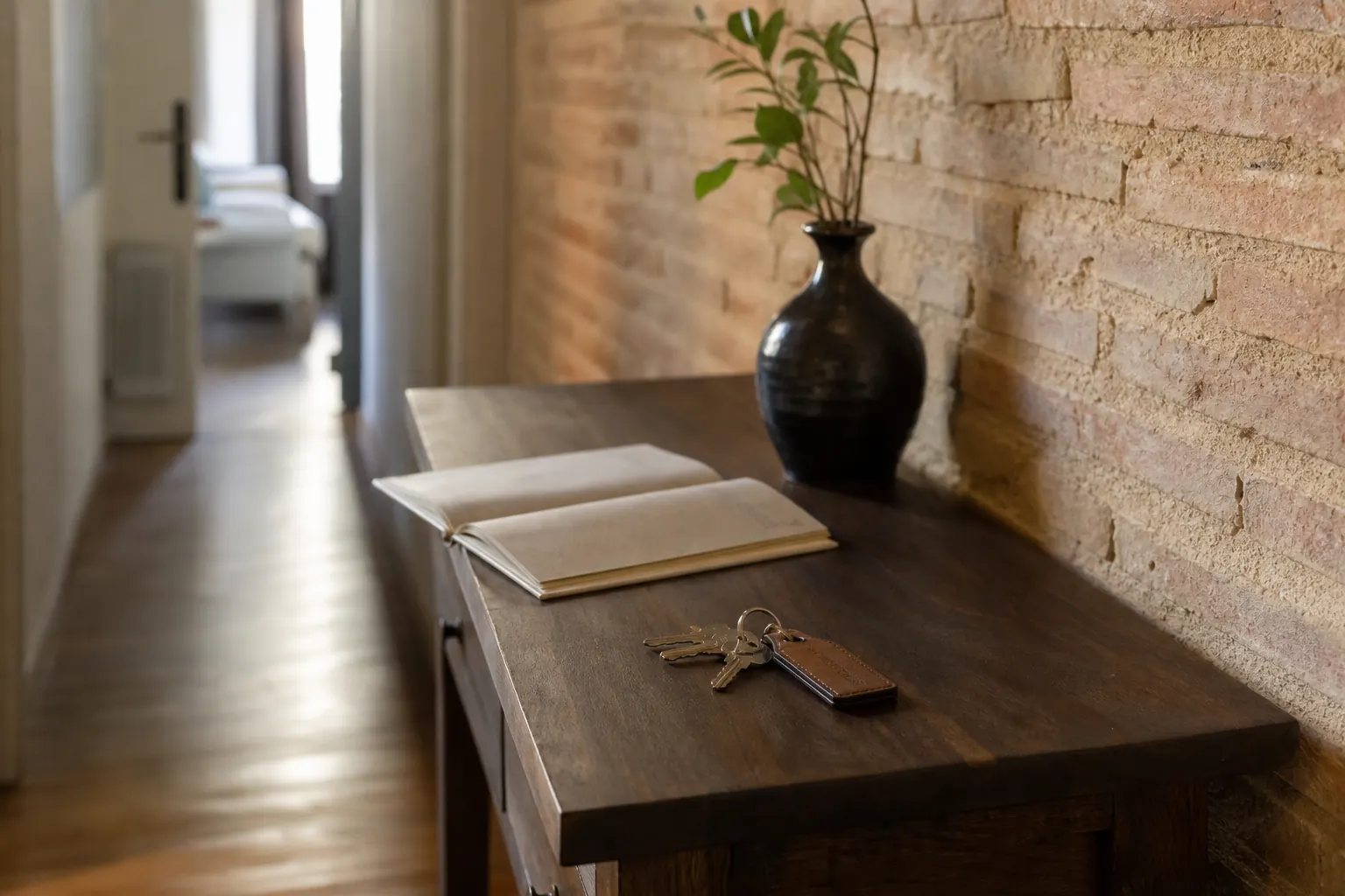 Console d’entrée avec un trousseau de clés étiqueté et un livret d’accueil ouvert