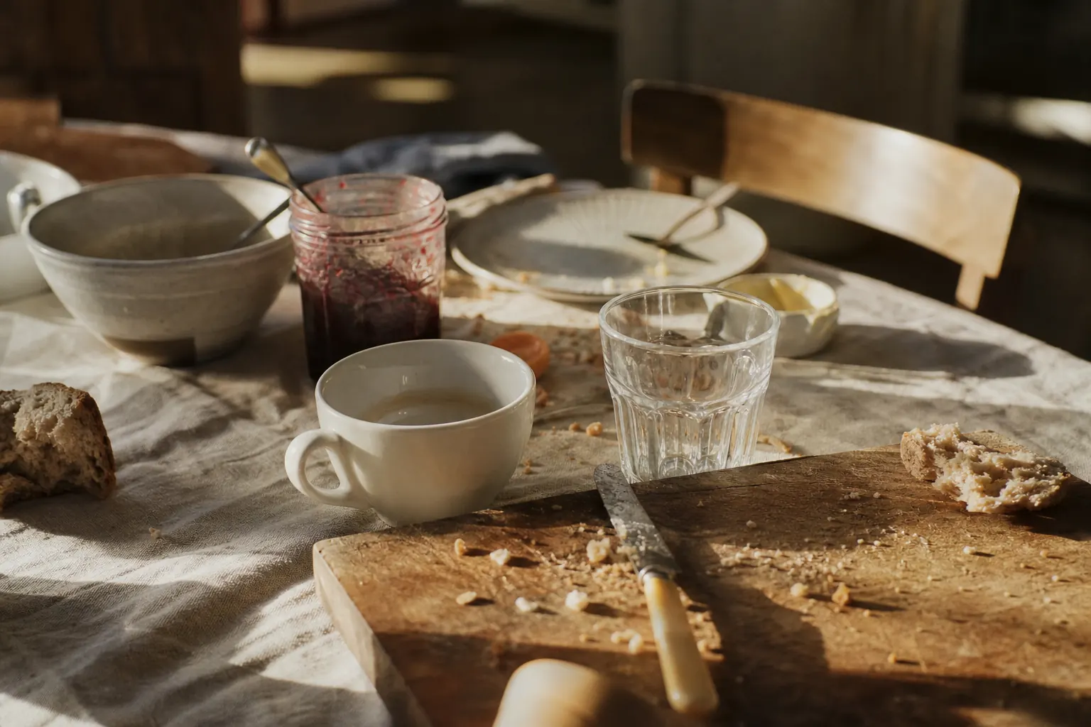Table de petit-déjeuner terminé, tasse vide et miettes sur une planche en bois